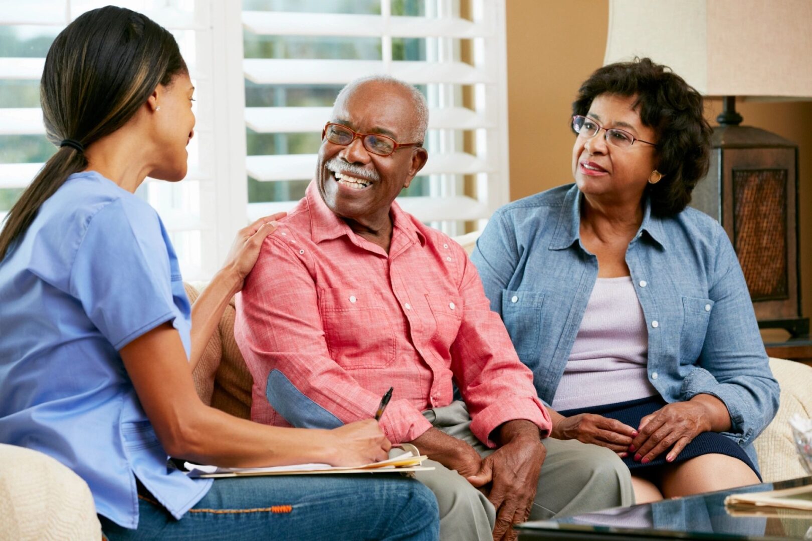 Female therapist assisting senior couple with exercises